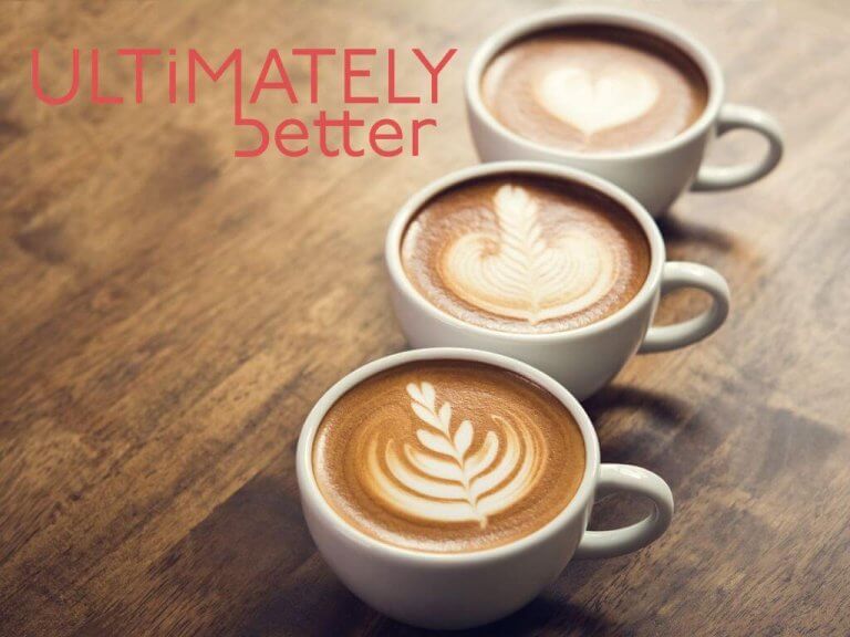 Ultimately Better logo beside three cups of coffee on a wooden work surface